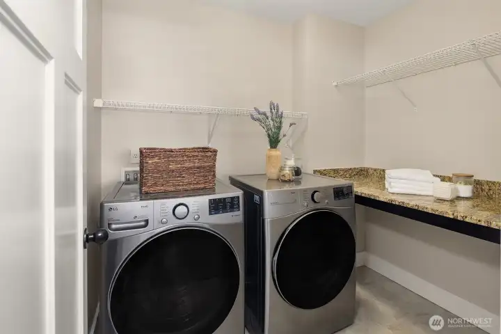 Utility room with full size washer and dryer, countertop space for folding and plenty of hanging space as well