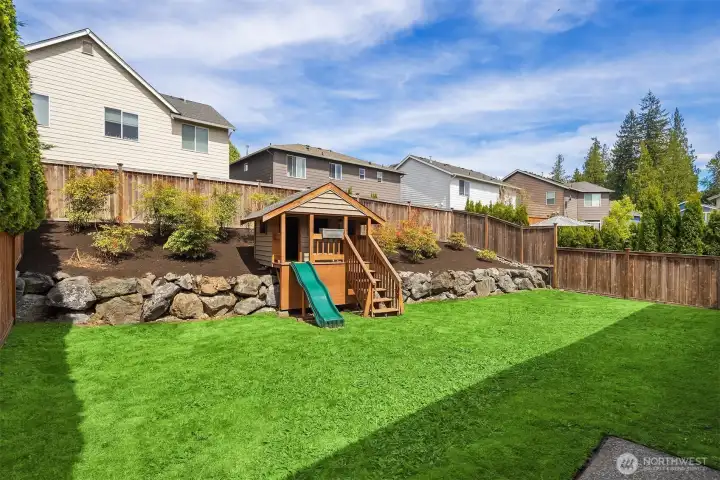 Great yard with a level lawn, playhouse and terraced garden space