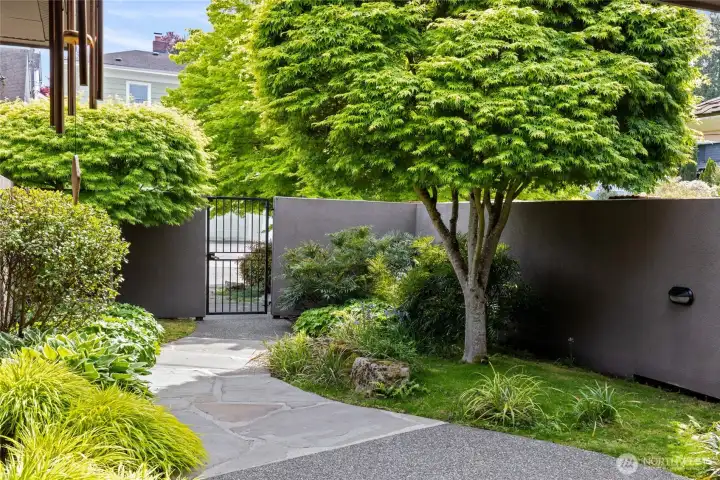 Private, fully fenced courtyard with Japanese-inspired landscaping, meandering stone paths, and gated access—ideal for relaxation and entertaining.
