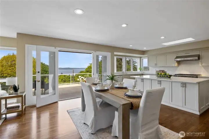 Bright, open dining area seamlessly connects to the chef’s kitchen and expansive view deck, creating ideal indoor-outdoor living with sweeping water vistas.