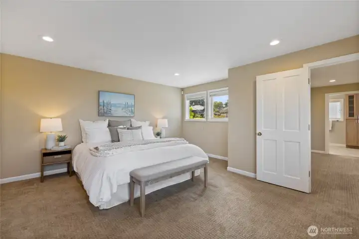Spacious upper-level primary suite offering a peaceful, private retreat with generous proportions, soft natural light, and direct access to a well-appointed en suite bath.