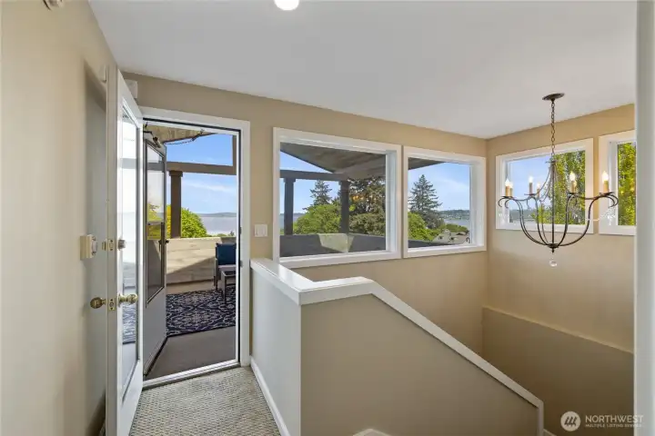 Upper-level landing with direct access to a private covered deck, perfectly positioned off the primary suite to capture natural light and scenic outlooks.