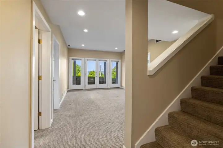 Spacious lower-level living area with recessed lighting and plush carpeting, offering a comfortable extension of the home with direct access to the walk-out patio.