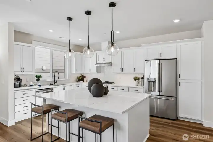 Dream kitchen showcased by expansive soft close cabinetry, full height backsplash, quartz counters, under cabinet lighting and a full complement of GE Cafe appliances including a gas range. Photo is same floor plan on Lot 1-homesite details can vary-see site agent