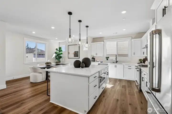 Huge kitchen island highlighted by designer pendant lighting. Photo is same floor plan on Lot 1-homesite details can vary-see site agent