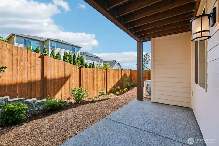 Covered patio off of lower level bonus room overlooks a fully fenced/landscaped sanctuary. Photo is same floor plan on Lot 1-homesite details can vary-see site agent