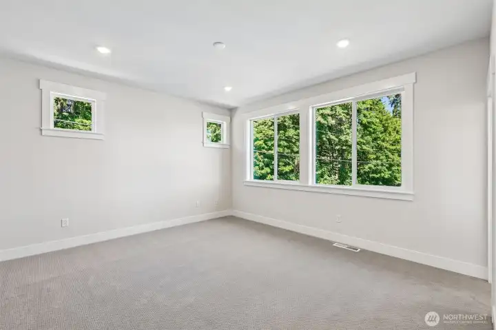 Primary bedroom with nature views provides a calming effect. Photo is same floor plan on Lot 1-homesite details can vary-see site agent