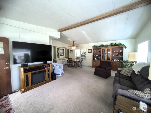 Large living/dining area with vaulted ceilings and picture windows