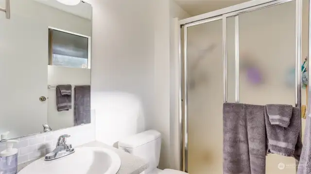 The primary bathroom offers a walk-in shower, vanity and window bathing the room in natural light.