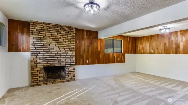 Downstairs boasts this massive bonus room with a second wood burning fireplace, classic wood paneled walls, new carpets and fresh paint.