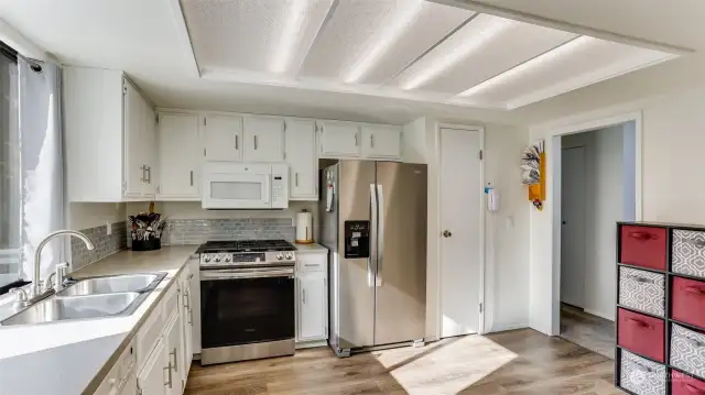 A bright kitchen equipped with sleek stainless steel appliances, ideal for any home chef.