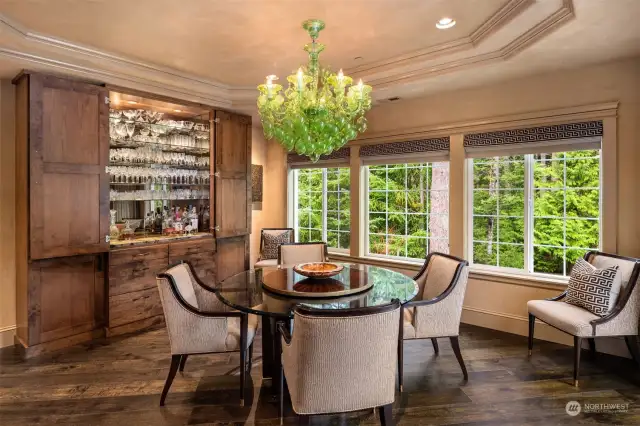 DeWils cabinetry, topped with stunning granite and glass, highlights your bar and can be easily closed off. The Baker 60-inch beveled glass-top dining table, complete with a removable lazy Susan, is perfectly complemented by the hand-blown Murano glass chandelier above.