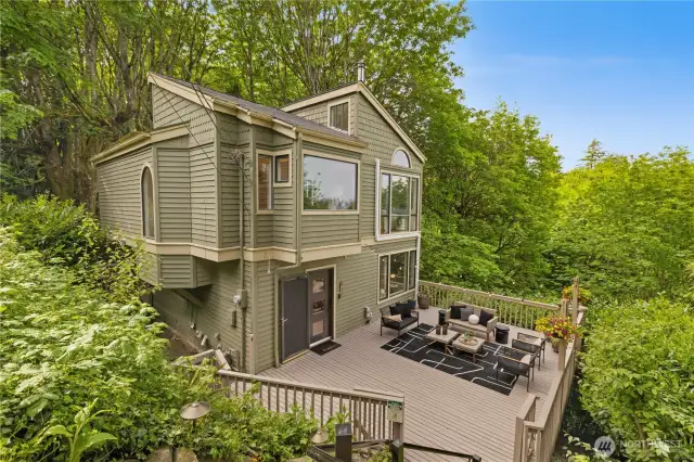 Main house with large front deck, nestled in the trees