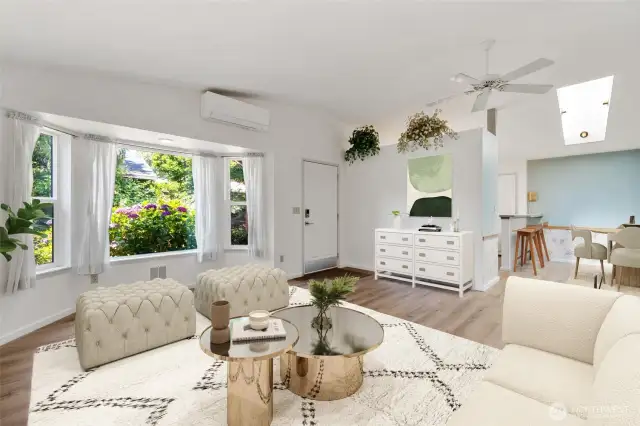 Vaulted ceilings and a skylight fill the space with natural light, while garden views and an open layout create a warm, easy flow into the dining area. (Virtually Staged)
