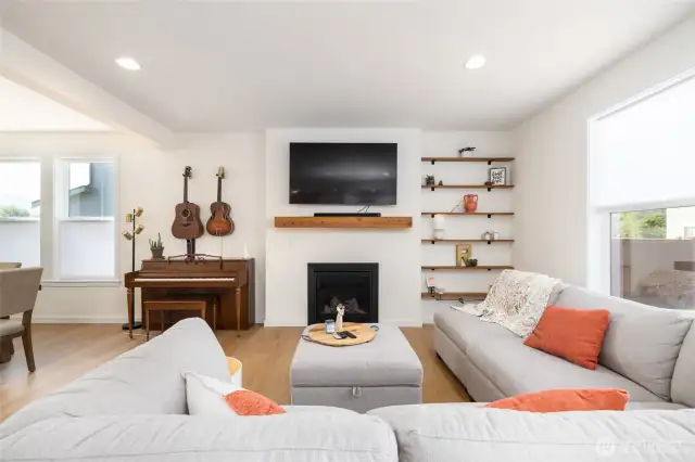 The great room has a gas fireplace, wood mantle and built in shelves.