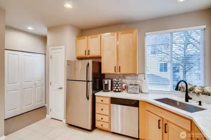 Open kitchen layout with ample counter space, pantry/storage, and adjacent laundry nook for convenience.