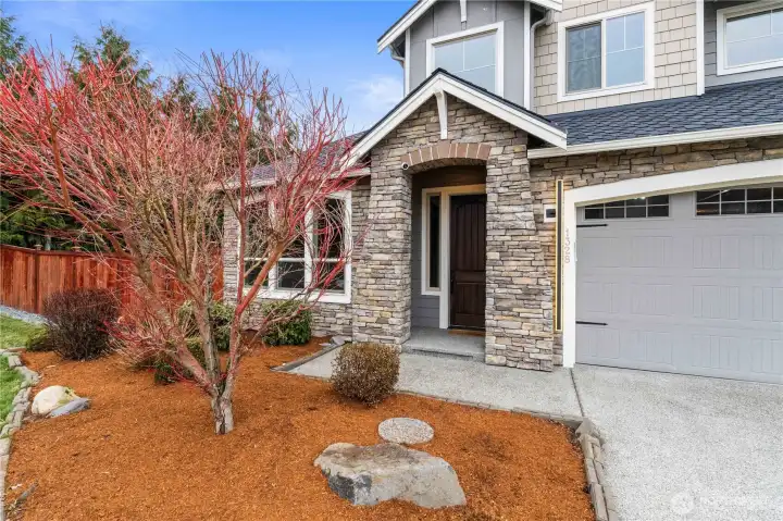 Welcoming front porch featuring stone accents
