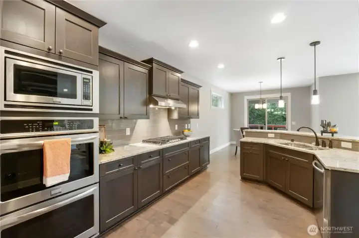 Spectacular gourmet kitchen with island, stainless appliances, eating space in informal eating area and the island