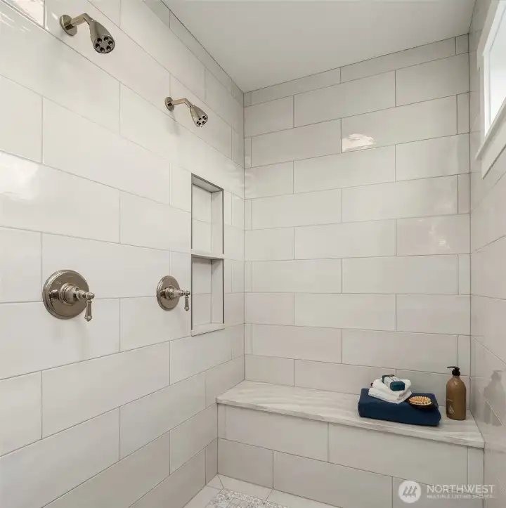 Primary bath with two walk in closets and beautiful tile work.