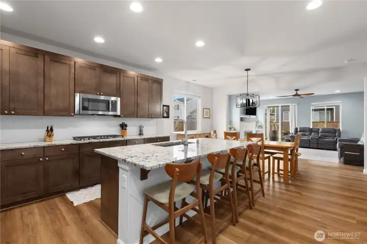 Spacious island kitchen with fully length backsplash and marble countertops.