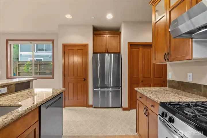 The stainless steel appliances of the kitchen include a French-door GE fridge and freezer (set smartly beside the pantry), out of the way if someone is cooking or loading the dishwasher.