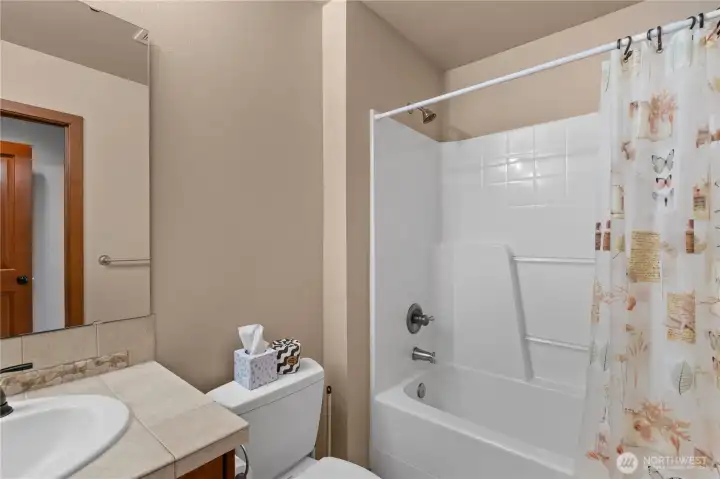 Another view of the primary suite full bathroom, showing the easy to clean shower and tub.