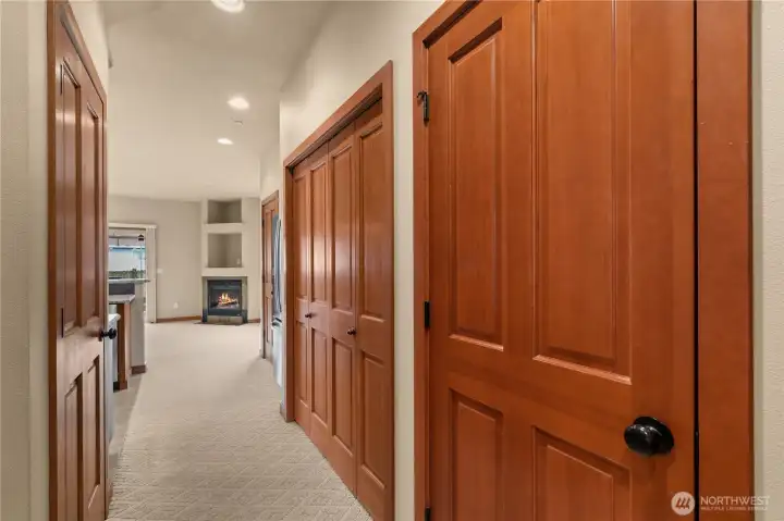 View from front entry or garage; bathroom to the right, closet on the left, laundry area with side by side washer and dryer are behind the bifold doors.