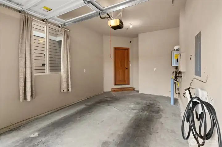 The garage includes a large window with black-out curtains, offering privacy or fresh air without opening the garage door. The tall ceilings offer an opportunity for overhead storage.
