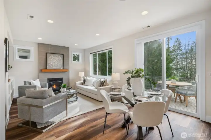 Step into the light-filled living and dining area, where newer flooring, a cozy gas fireplace, and custom built-in cabinetry create an inviting space to gather