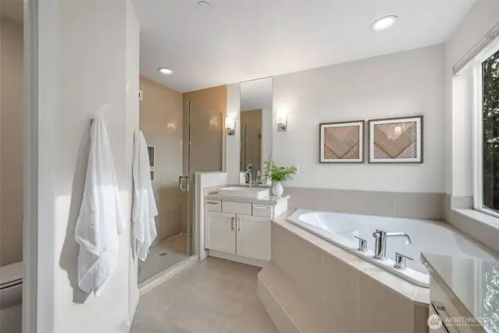 The primary has dual closets, and a luxurious five-piece en-suite bath