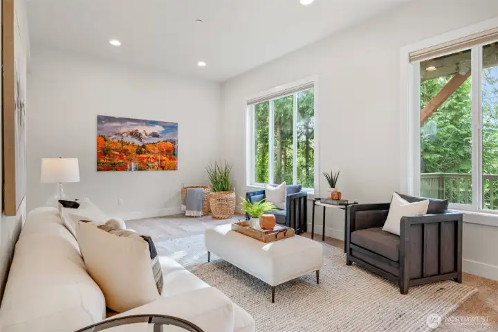 The spacious family room with slider to a private deck, and peaceful tree-lined views