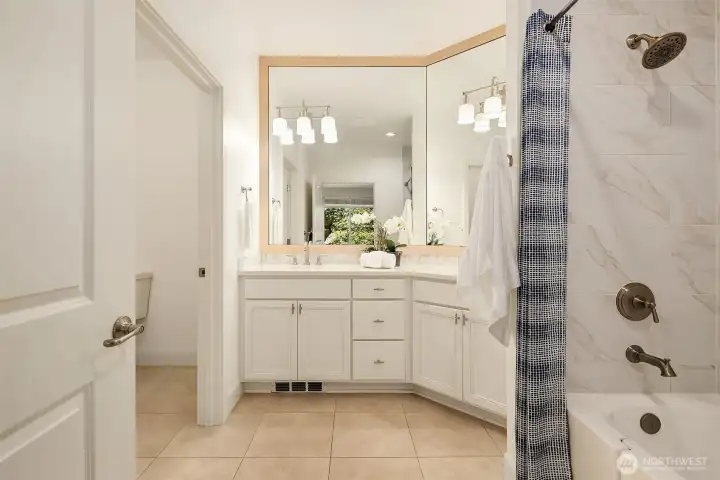remodeled bathroom is stylishly updated with dual vanities, sleek tile floors and generous space to move comfortably