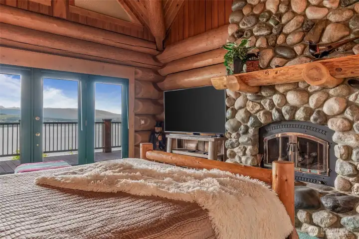 River rock fireplace in primary bedroom.