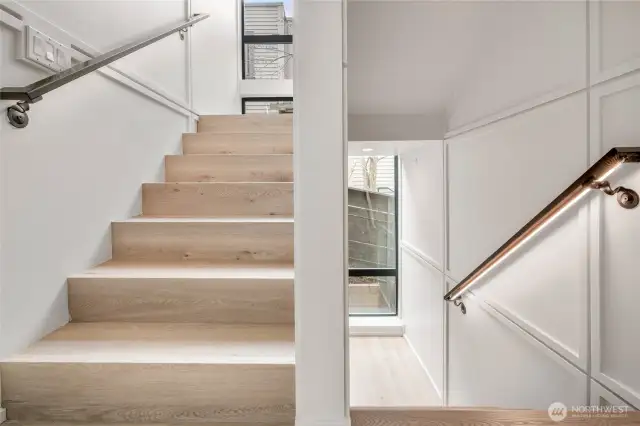 Contemporary Glow: The illuminated railing on the stairs adds a stylish, modern touch to the home's design.