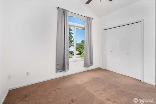 Upper level bedroom no. 1 with tall ceilings and a ceiling fan to circulate fresh air.