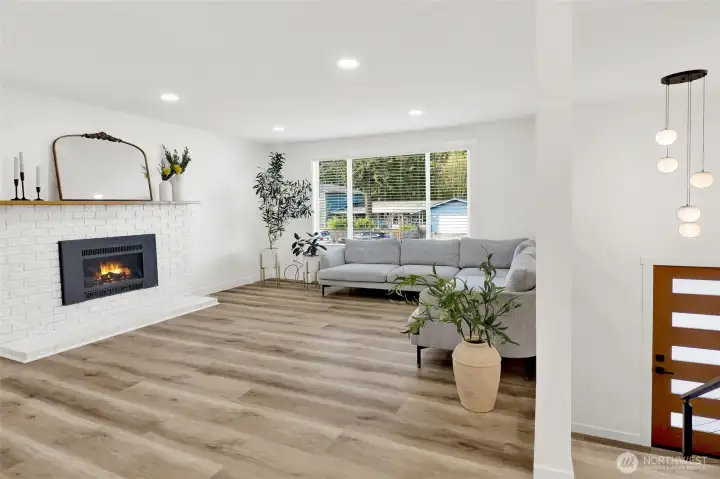 Bright, fully remodeled living room with fireplace, creating a warm and inviting space to gather!