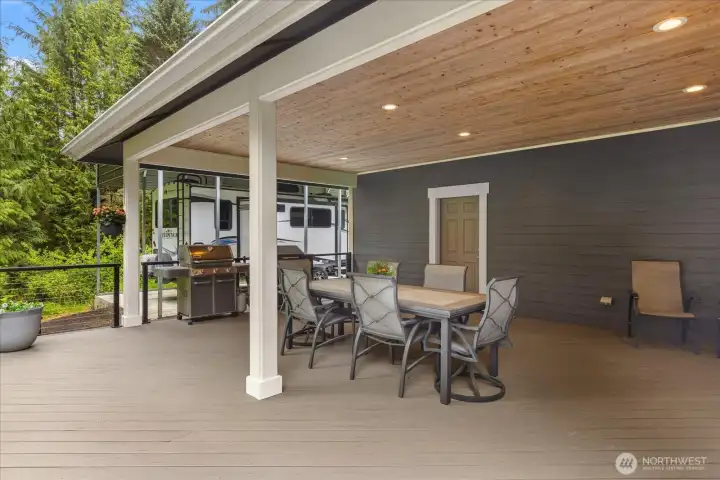 Another view of covered outdoor dining and expansive decking.