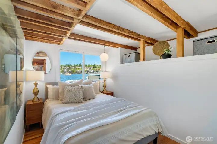 One of the main floor bedrooms - elevated with a raised ceiling, exposed beams, and added storage.