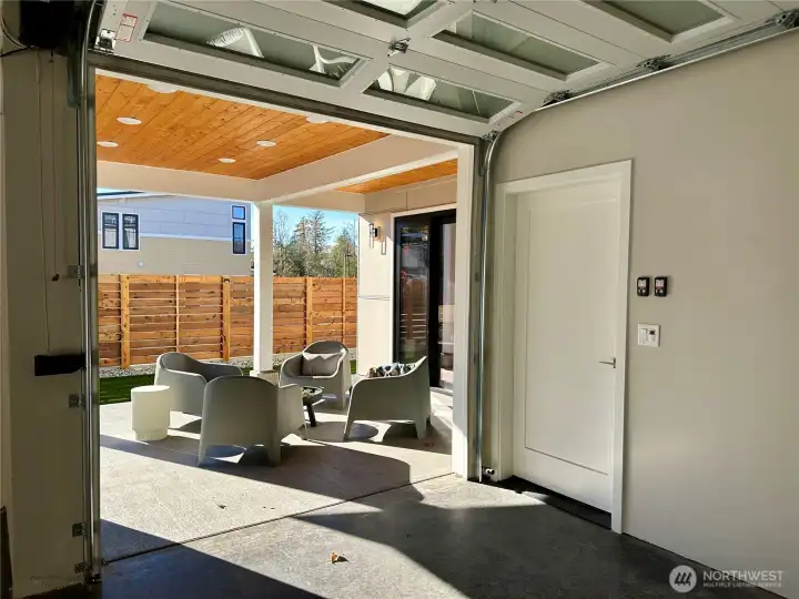 Secondary roll up garage door on patio side for expansion of outdoor space and entertaining