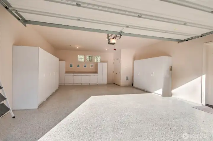 2-car garage with epoxy flooring and custom cabinets