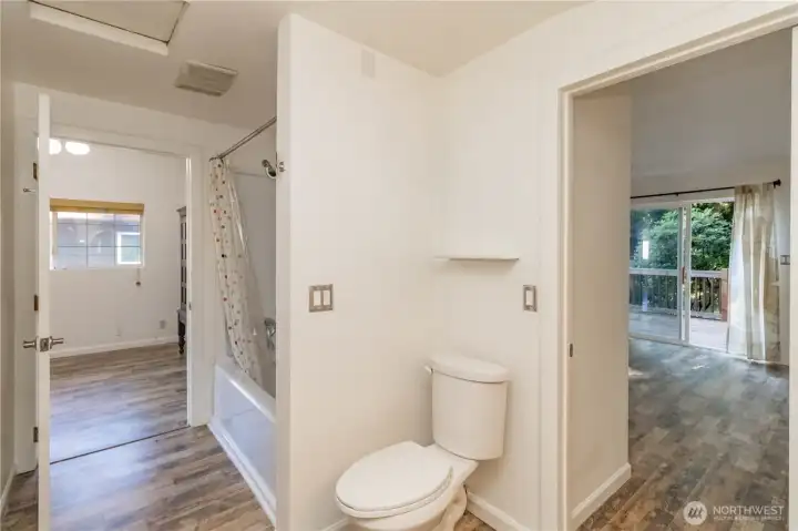Main full bath featuring convenient access to the living area on the left and the primary suite on the right.