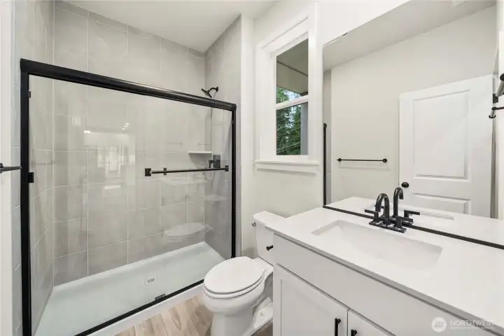 Main level bath. Photos of a previously completed home. Actual colors and finishes may vary. See site agent for details.