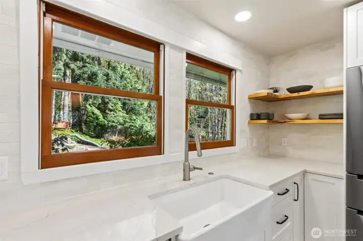 The kitchen overlooks the peaceful backyard setting.