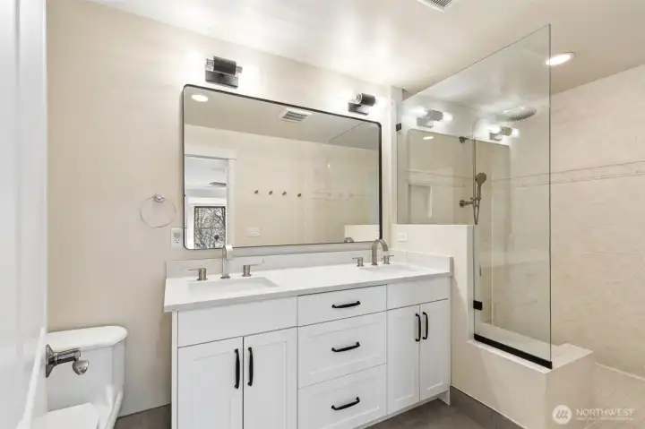 Beautifully updated primary bath featuring extensive tile work, a new vanity, and new fixtures.