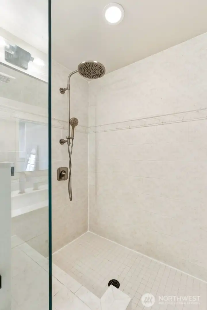 Primary shower features beautiful tilework and a glass enclosure.