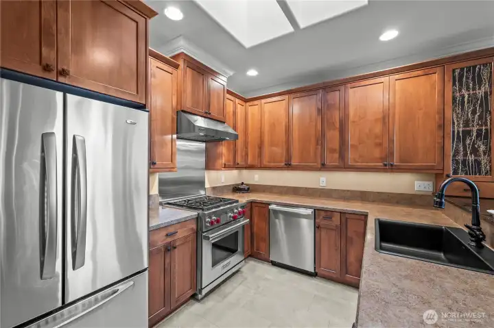 Abundant cabinetry, generous counter space, and skylights fill the kitchen with natural light.