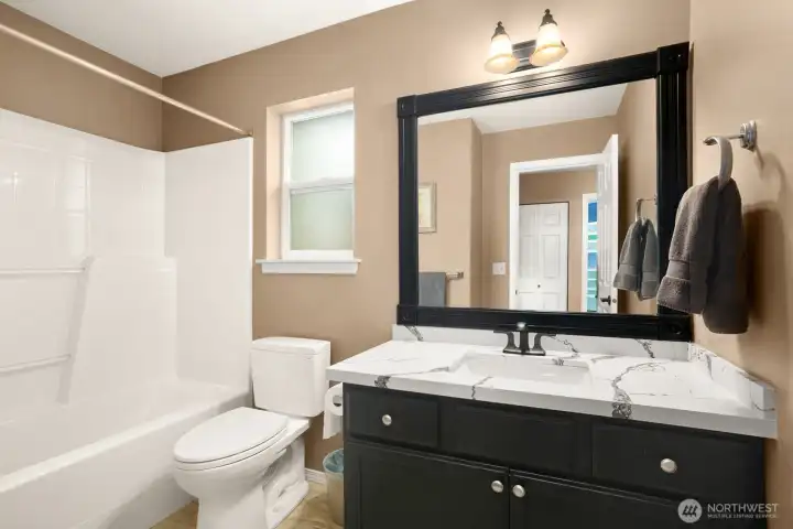 Refreshed guest bathroom with quartz counters.