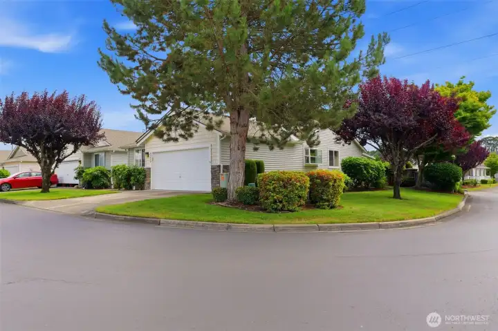 Nestled on a beautifully landscaped corner lot in gated Country Place — mature trees, manicured grounds, and true pride of ownership throughout the community.
