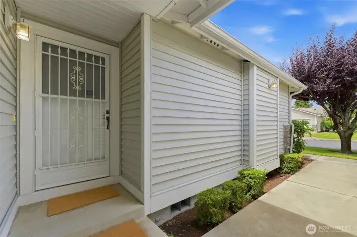 A private, covered front entry with security storm door — a clean, welcoming first impression.