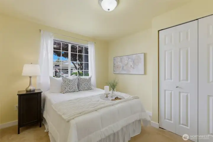 Light-filled second bedroom with large window and double closet — bright, airy, and beautifully staged by Details.